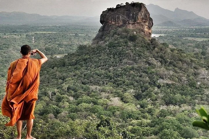 Buddhist monk taking a photo of Sigiriya rock from a viewpoint