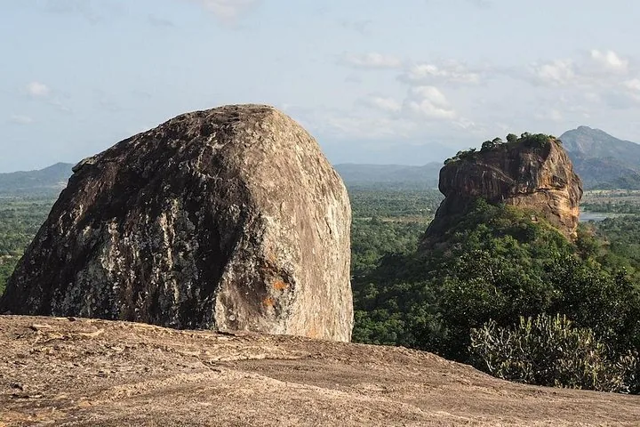 Große Felsbrocken auf dem Pidurangala-Felsen mit dem Sigiriya-Felsen im Hintergrund