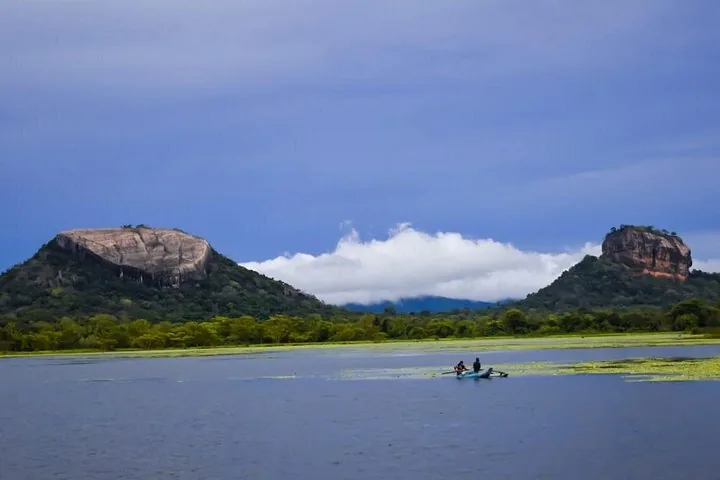 Lago con una barca, con entrambe le rocce di Pidurangala e Sigiriya visibili