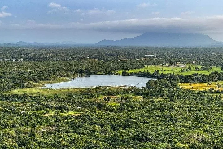 Wide landscape view showing a lake, fields, and forested areas
