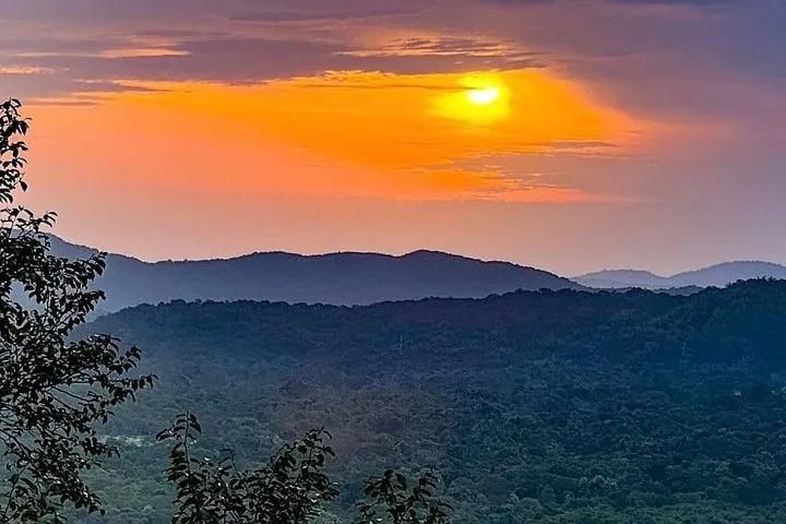 Goldener Sonnenuntergang über einer silhouettierten Hügellandschaft