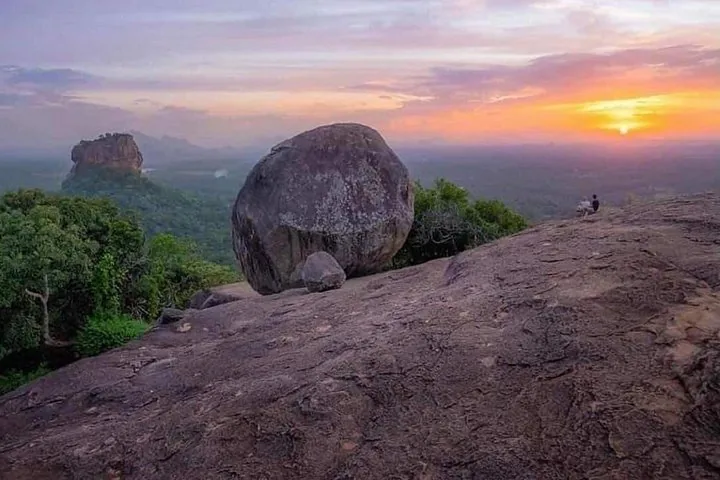 Gran formación rocosa en Pidurangala con Sigiriya al fondo al atardecer